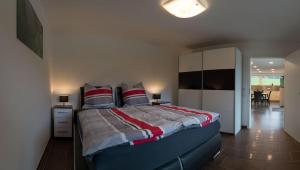 ein Schlafzimmer mit einem großen Bett mit roten und weißen Kissen in der Unterkunft Moderne barrierefreie Ferienwohnung in Buchenberg