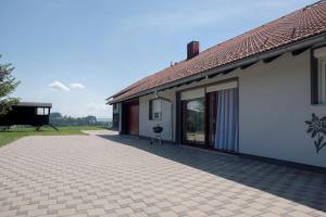 a building with a patio next to a house at Moderne-barrierefreie-Ferienwohnung in Buchenberg +9 photos