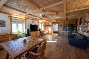 a living room with a wooden ceiling and a table at Bauern-Ferienhaus-im-Allgaeu in Buchenberg