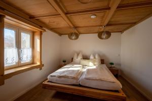 Bett in einem Zimmer mit Holzdecke in der Unterkunft Bauern-Ferienhaus im Allgäu in Buchenberg