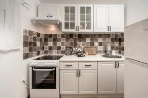 a small kitchen with white cabinets and a sink at Olive Grove in Bar