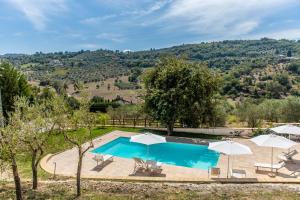 Bild eines Pools mit Sonnenschirmen und Stühlen in der Unterkunft Appartamento per quattro con piscina in villa in Agropoli