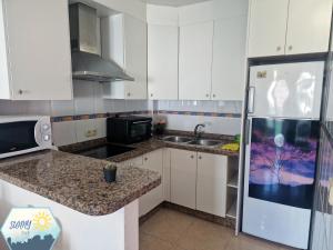 a kitchen with white cabinets and a refrigerator at Sunny Churriana-Airport in Málaga