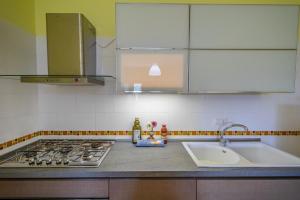 eine Küchentheke mit einer Spüle und einem Herd in der Unterkunft Appartamento per quattro con piscina in villa in Agropoli