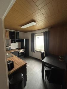 a kitchen and dining room with a table and a window at MR Ferienwohnung - Wohnung Mary in Barsinghausen +4 photos
