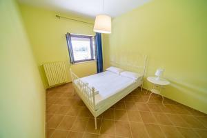 Kleines Zimmer mit einem Bett und einem Fenster in der Unterkunft Appartamento per quattro con piscina in villa in Agropoli