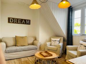 - un salon avec deux canapés et une table dans l'établissement Appartement cosy bord de mer, à Port-en-Bessin-Huppain