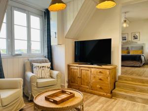 - un salon avec une télévision à écran plat sur une armoire en bois dans l'établissement Appartement cosy bord de mer, à Port-en-Bessin-Huppain