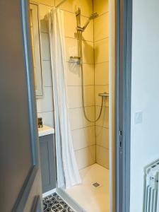 La salle de bains est pourvue d'une douche et d'un lavabo. dans l'établissement Appartement cosy bord de mer, à Port-en-Bessin-Huppain