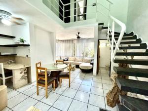 ein Wohnzimmer mit einer Treppe, einem Tisch und Stühlen in der Unterkunft Fantastico Duplex Familiar con AC Wifi & Alberca #1 in Mérida