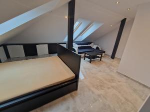 een loft met een bed en stoelen in een kamer bij Apartament KNIEJA LUX in Tuchola