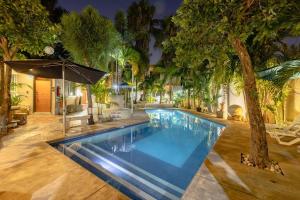 einen Pool in einem Garten mit Bäumen in der Unterkunft Fantastico Duplex Familiar con AC Wifi & Alberca #1 in Mérida