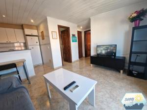 a living room with a white table and a tv at Sunny Churriana Airport III in Málaga