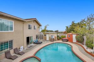 a swimming pool with chairs and a house at Colorful and Cozy Haven with Heated Pool in Rodeo