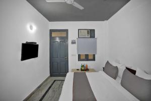 a white room with a bed and a blue door at OYO Flagship Premium Villa in New Delhi