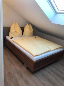 a bed with two pillows on it in a room at Zweizimmer-Apartment in Buchenberg