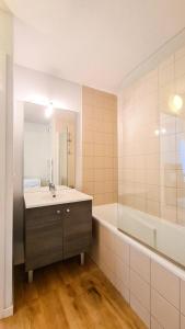 a bathroom with a sink and a tub and a mirror at Résidence La Petite Ourse - 3 Pièces pour 6 Personnes 83 in Flaine