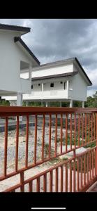 a house with a wooden fence in front of it at home stay harith & humaira in Lengging