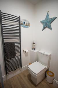 a bathroom with a toilet and a starfish on the wall at Quite and comfortable Eastbourne in Eastbourne