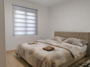 a bedroom with a bed with two pillows and a window at Apartman Mani in Višegrad