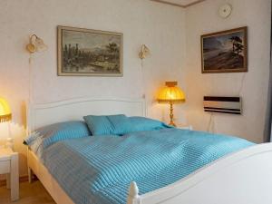 1 dormitorio con 1 cama con sábanas azules y 2 lámparas en Holiday home Fjällbacka VII en Fjällbacka