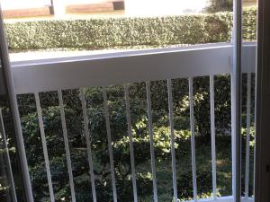 a fence on a balcony with a hedge at Appartement T2 in Six-Fours-les-Plages