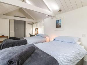 Tres camas en una habitación con paredes blancas. en An Skyber, en Penzance