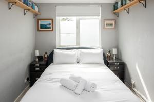 倫敦的住宿－Kennington 3BR Haven: Dog-Friendly/Central London，卧室配有白色的床和2条毛巾