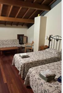 a hotel room with two beds and a couch at Acea do Bubal in Os Peares