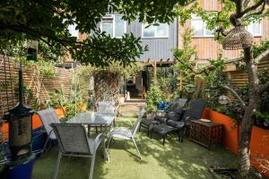 倫敦的住宿－Kennington 3BR Haven: Dog-Friendly/Central London，一个带椅子和桌子的庭院和一棵树