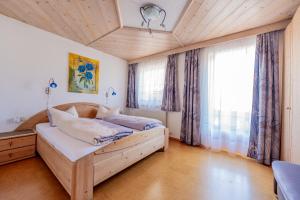 a bedroom with a bed and a large window at Ferienwohnung Ausblick Zillertal in Hainzenberg