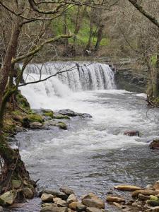 a waterfall in the middle of a river at Acea do Bubal in Os Peares