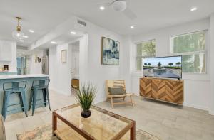 a living room with a tv and a table at Red Maple by AvantStay Walk to Folly Beach in Folly Beach