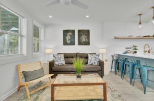 a living room with a couch and a table at Red Maple by AvantStay Walk to Folly Beach in Folly Beach