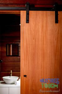 a wooden door in a bathroom with a sink at Casa da Fontinha in Praia da Vitória +16 photos