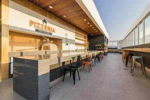 a pizza restaurant with a long counter and chairs at 905 A sua casa em Porto Alegre na região central da cidade in Porto Alegre