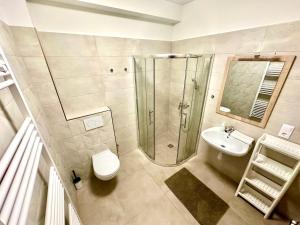 a bathroom with a shower and a toilet and a sink at Ady Corner Prémium Apartmanok - Siófok in Siófok +19 photos