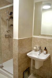 y baño con lavabo, ducha y espejo. en 1 Bedroom Apartment in Central Manchester, en Mánchester