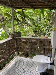 a bathroom with a toilet in front of a forest at Comfortable bungalow with a beautiful view in Munda