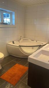 a bathroom with a tub and a toilet and a sink at Heimro in Torvetjørn