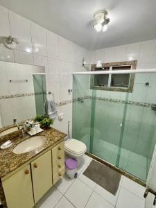 een badkamer met een douche, een toilet en een wastafel bij 02 quadras do mar/ Espaçoso/chuveirão externo in Vitória