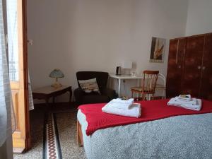 a bedroom with a bed with a red blanket and a chair at Casa Genny Costa in Florence