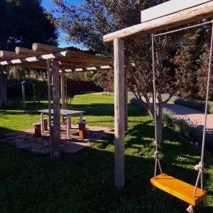 a wooden pergola with a picnic table and a swing at Chácara Por do Sol in Farroupilha