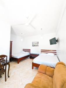 ein Schlafzimmer mit einem Bett und einem Sofa in der Unterkunft Casa Anastacia in San Ignacio