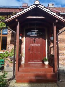 an entrance to a brick house with a red door at agroturystyka Drużno in Elblag