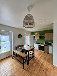 a kitchen with a table and a bench in a room at Gîte de la petite tour in Pontorson