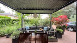 a dog laying on a couch under a pergola at Casa Lovo in Saint-Laurent-de-Mure