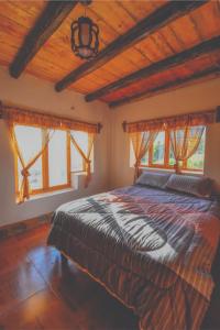 ein Schlafzimmer mit einem großen Bett in einem Zimmer mit Fenstern in der Unterkunft Nápoles Ecolodge Hotel in Anta