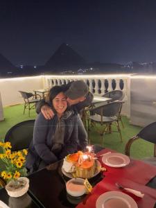 a man and a woman sitting at a table with a cake at Pyramid stars inn in Cairo