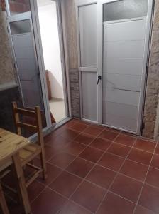 Habitación con 2 puertas, mesa y suelo de baldosa. en Appartement lumineux, en Kouba